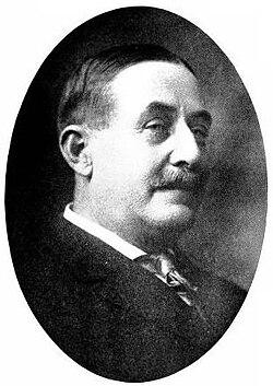 Portrait photograph of John Reed Yale (1855–1925) in oval frame, white-haired with full mustache, formal dark suit.