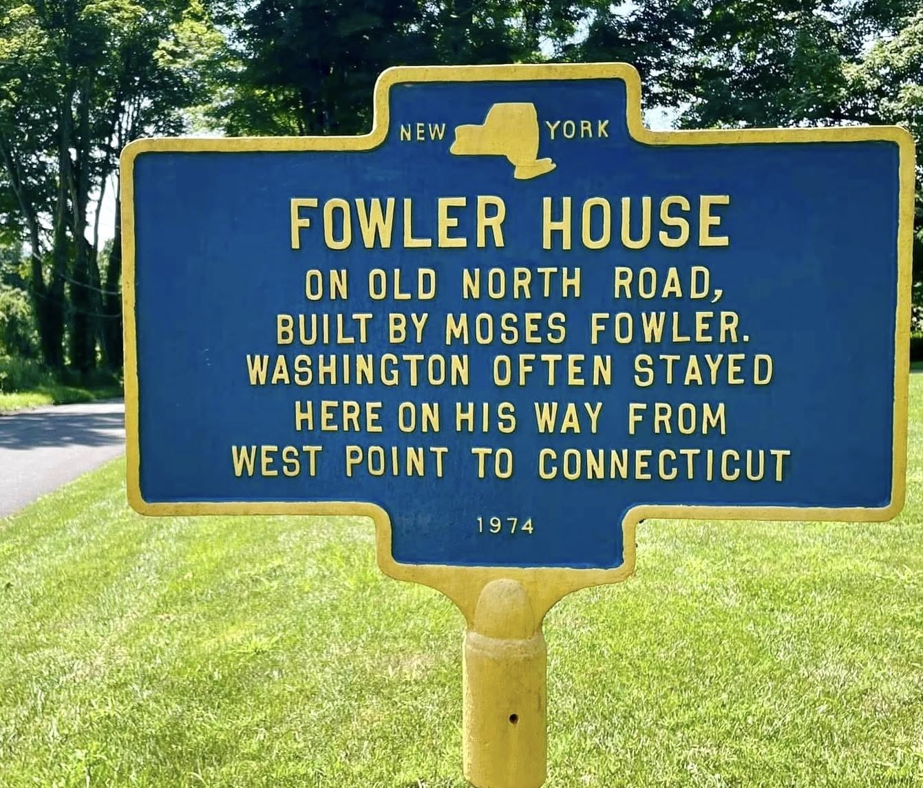 Blue and yellow New York State historic marker reading FOWLER HOUSE: On Old North Road, built by Moses Fowler. Washington often stayed here on his way from West Point to Connecticut. 1974.