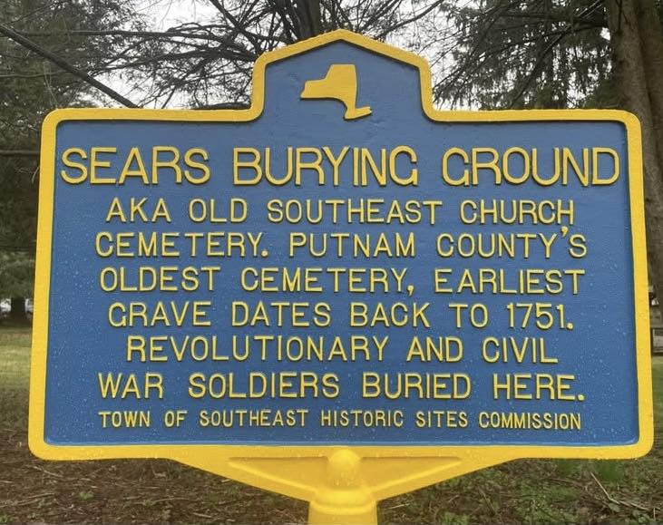 Blue and yellow New York State-style historic marker reading SEARS BURYING GROUND, aka Old Southeast Church Cemetery. Putnam County's oldest cemetery, earliest grave dates back to 1751. Revolutionary and Civil War soldiers buried here. Town of Southeast Historic Sites Commission.