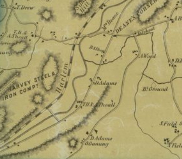 Detail of an 1854 county map, printed in tan with hachured hills: the Harlem Railroad and the Croton River run diagonally through the sheet; a tract west of the tracks is lettered &lsquo;Harvey Steel & Iron Comp&rsquo;y&rsquo;; roads meet at &lsquo;Deane&rsquo;s Corners&rsquo; with a school; farmstead dots are named T.H. & A. Theall, D. Adams, O. Ganong, A. Wood, and B&rsquo;l Ground.
